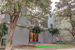 a white building with trees in front of it at RROOMS Hotel Orphic Inn in Lucknow