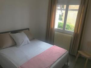 a bed in a bedroom with a window at Maison bord de Mer au calme sous les Pins in Carry-le-Rouet