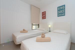 two beds with towels on top of them in a room at Beachside Attico 3 bed 2 bath in El Campello