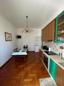 una cucina con mobili in legno e un tavolo al suo interno di Testaccio 100 a Roma