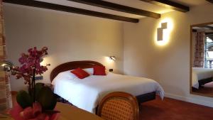 A bed or beds in a room at Hotel Restaurant Père Benoît