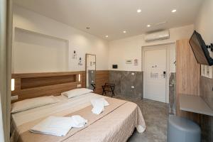 a bedroom with a large bed with towels on it at GreRos Toledo H Historical Center in Naples, by ClaPa Group Dislocated Hospitality in Naples