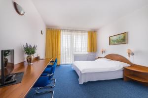 pokój hotelowy z łóżkiem i biurkiem w obiekcie La Residence Kasandra w Jastrzębiej Górze