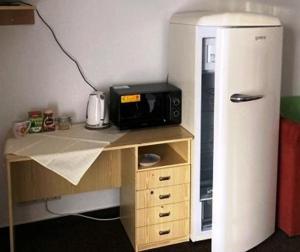 a small desk with a refrigerator and a microwave at Izba s výhľadom na Tatry in Poprad +9 photos