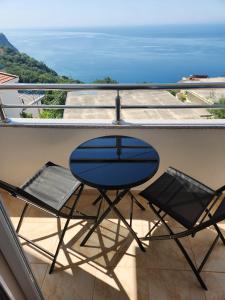 a table and two chairs on a balcony at Sunny Apartment in Prijevor