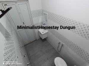 une salle de bain avec un lavabo et des toilettes dans l'établissement Minimalist Homestay Dungun 2, à Kampong Sura Tengah