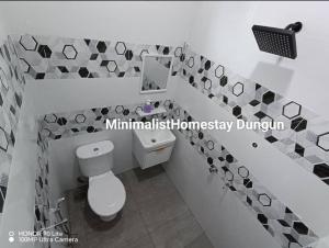 une salle de bain avec des toilettes blanches et un miroir dans l'établissement Minimalist Homestay Dungun 2, à Kampong Sura Tengah