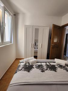 a bedroom with a large bed with two towels on it at Sunny Apartment in Prijevor
