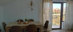 a dining room table with chairs and a clock on the wall at Vila Onur Techirghiol in Techirghiol