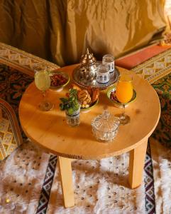 a wooden table with a tray of food and drinks on it at Merzouga Exclusive Camp in Merzouga