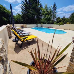 Un patio con sillas y una piscina. en Les Écuries, 