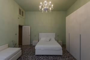 1 dormitorio con 2 camas y lámpara de araña en Alighieri Theatre Charming Suite, en Rávena