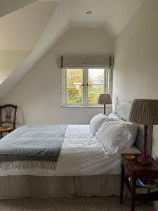 チッペナムにあるCharming one bedroomed pied a terre in rural locationsの窓のある大きな白いベッドのある寝室