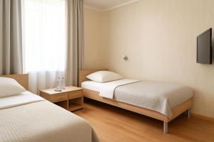 a hotel room with two beds and a television at Waldhotel Bad Münstereifel in Bad Münstereifel