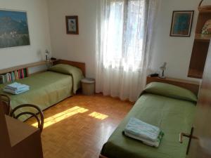 a room with two beds and a table and a window at Casa Alice in Mezzano
