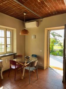 uma sala de jantar com mesa e cadeiras de vidro em Country House Pais - Relax in jacuzzi tra i vigneti em Quargnento