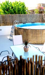 a table and chairs next to a swimming pool at IKARUS apartment with courtyard & pool in Chania in Stérnai