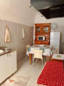 a kitchen with a table with chairs and a refrigerator at Domus 34 in Sassari