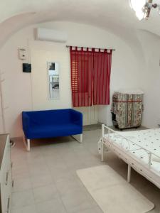 a room with two beds and a blue couch at Domus 34 in Sassari