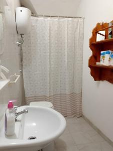 a bathroom with a white sink and a shower curtain at Domus 34 in Sassari