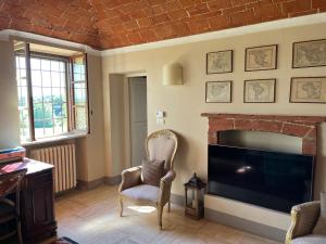 uma sala de estar com lareira e televisão em Country House Pais - Relax in jacuzzi tra i vigneti em Quargnento