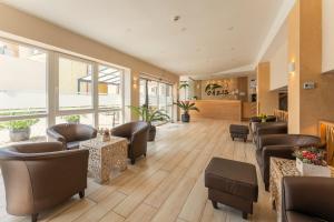 een wachtkamer met lederen stoelen, tafels en ramen bij OÁZIS Hotel*** in Nagykanizsa