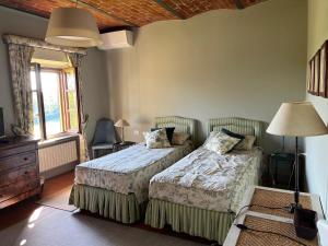 um quarto com duas camas e uma janela em Country House Pais - Relax in jacuzzi tra i vigneti em Quargnento mais 30 fotografias