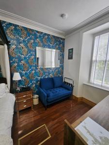 a blue couch in a room with blue wallpaper at Norlande in Lerwick