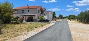 a house with a car parked on the side of a road at Modern apartment in Biograd na Moru