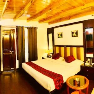 Un dormitorio con una cama grande en una habitación. en Hotel Legacy, en Nainital