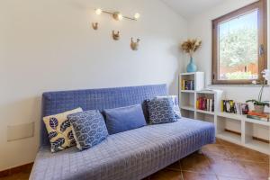 Un sofá azul con almohadas en una sala de estar. en Indaco Blu, en SantʼAnna Arresi