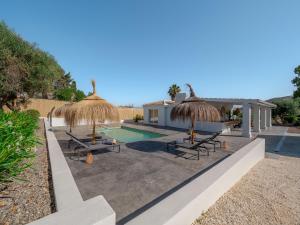 a villa with a swimming pool and straw umbrellas at Casa Laflornb in Alhaurín el Grande
