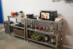 a metal shelf with a microwave on top of it at ACD HOTELs in Chennai