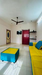 sala de estar con sofá amarillo y azul en Vue Marine- 1bhk near Rock beach, en Pondicherry