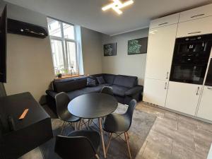 a living room with a couch and a table and chairs at DWORAK apartment in Przemyśl