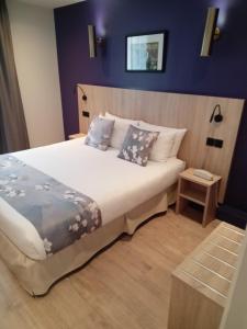 a bedroom with a large bed with blue walls at Hotel Modern Est in Paris