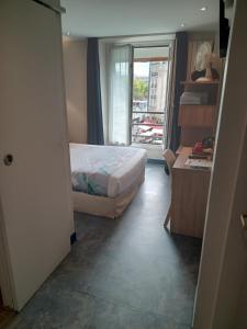 a bedroom with a bed and a large window at Hotel Modern Est in Paris