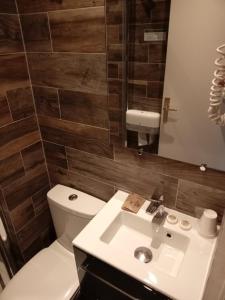 a bathroom with a white toilet and a sink at Hotel Modern Est in Paris