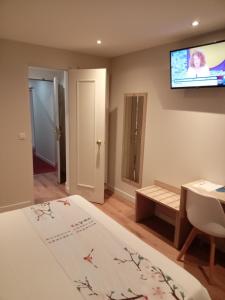 a bedroom with a bed and a flat screen tv at Hotel Modern Est in Paris