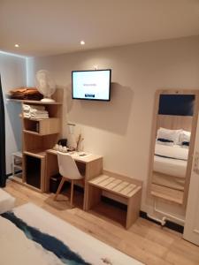 a room with a desk and a television on the wall at Hotel Modern Est in Paris