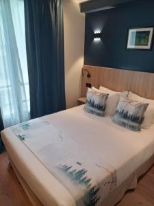 a bedroom with a large bed with blue walls and pillows at Hotel Modern Est in Paris
