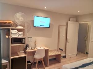 a room with a desk and a television on the wall at Hotel Modern Est in Paris