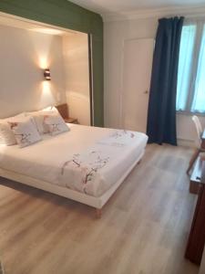 a bedroom with a white bed with a mirror at Hotel Modern Est in Paris