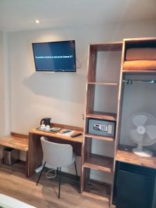 a room with a desk with a computer and a shelf at Hotel Modern Est in Paris