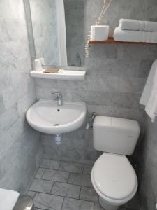 a white bathroom with a toilet and a sink at Hotel Modern Est in Paris
