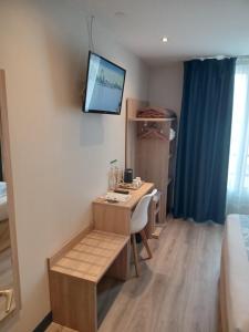 a room with a desk and a tv on the wall at Hotel Modern Est in Paris