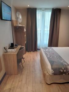 a hotel room with a bed and a desk with a computer at Hotel Modern Est in Paris