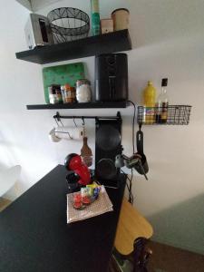 a kitchen with a counter top with a microwave and shelves at Petit nid au coeur de Vendôme in Vendôme