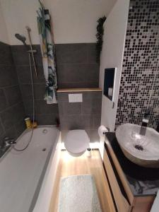 a bathroom with a tub and a toilet and a sink at Petit nid au coeur de Vendôme in Vendôme