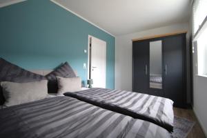 a bedroom with a large bed with blue walls at Ferienhaus mit Garten in Bad Schwartau für bis zu 6 Personen in Bad Schwartau